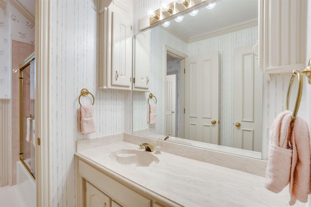 3068 High Ridge Drive Grapevine, TX 76051 - Photo 26 of 40 Vanity with an integrated sink, polished brass fixtures, wall-mounted mirror, and built-in cabinetry
