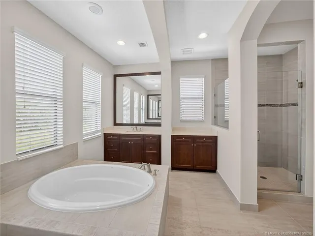 a spacious bathroom with double vanity and a large mirror