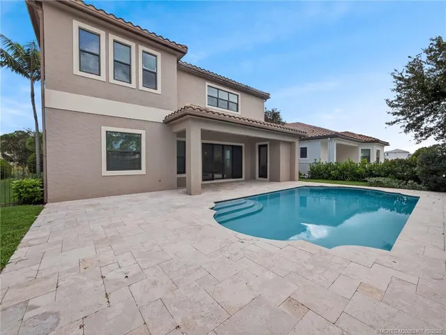 a front view of a house with swimming pool and glass windows