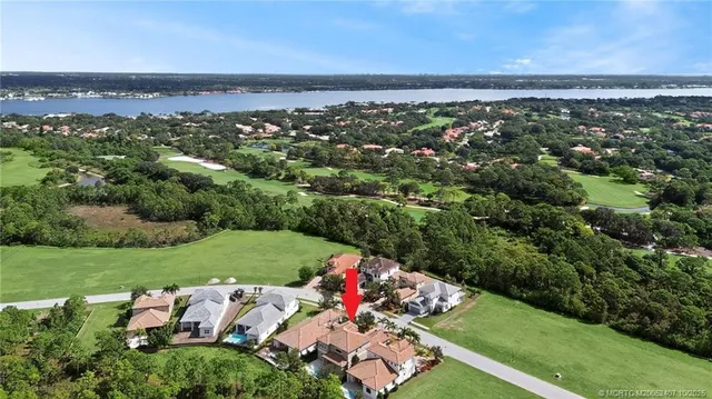 an aerial view of a houses with a yard and lake view
