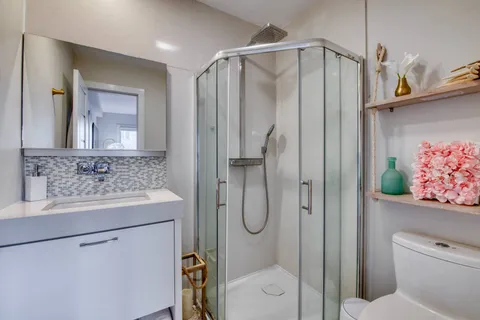 a bathroom with a shower sink and mirror