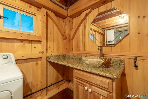 a bathroom with a granite countertop sink and a shower