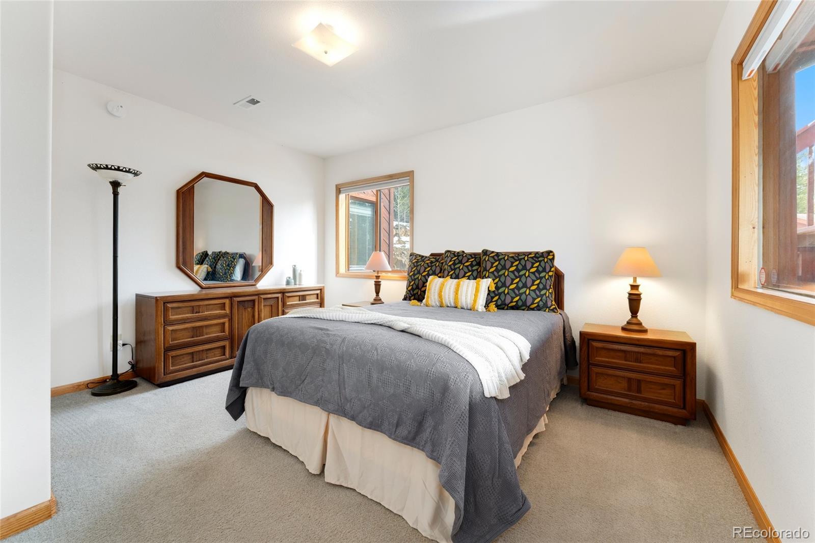 660 Coyote Circle Black Hawk, CO 80422 - Photo 27 of 46 a bedroom with a bed and a dresser with mirror