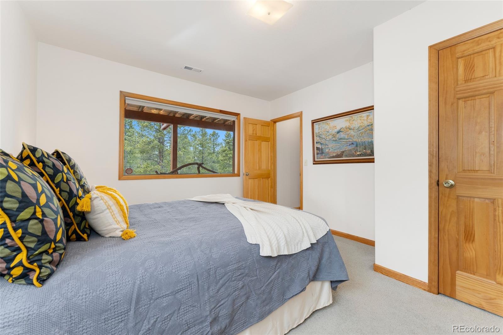 660 Coyote Circle Black Hawk, CO 80422 - Photo 28 of 46 a bedroom with a bed and a painting on the wall