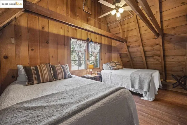a large bedroom with bed and wooden floor