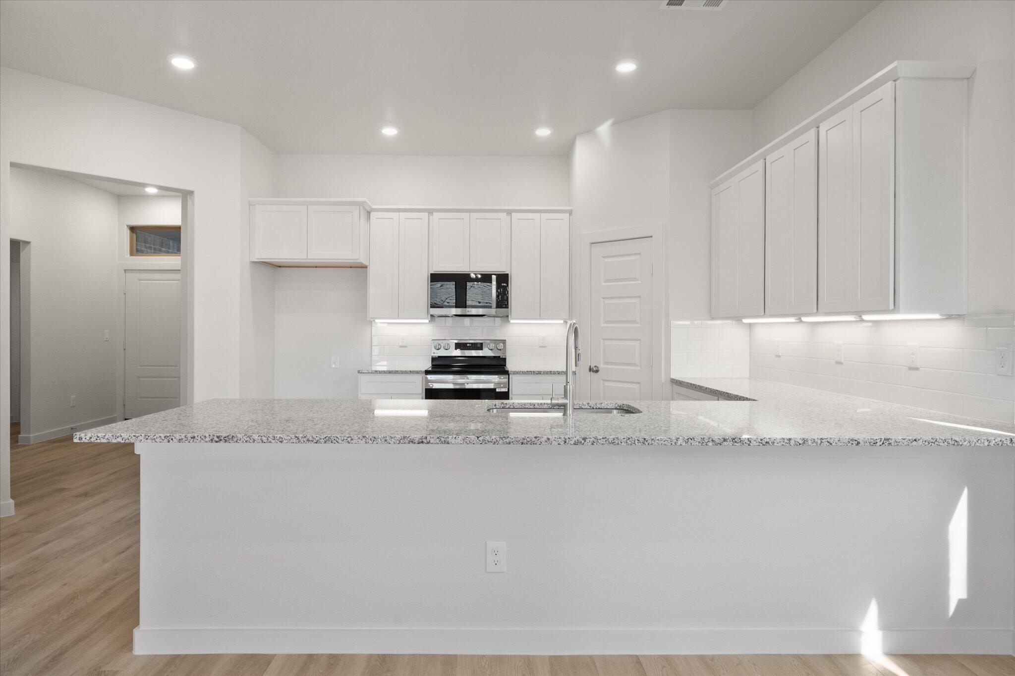 3003 138th Place Lubbock, TX 79423 - Photo 6 of 21 a kitchen with stainless steel appliances granite countertop a sink a stove and a refrigerator