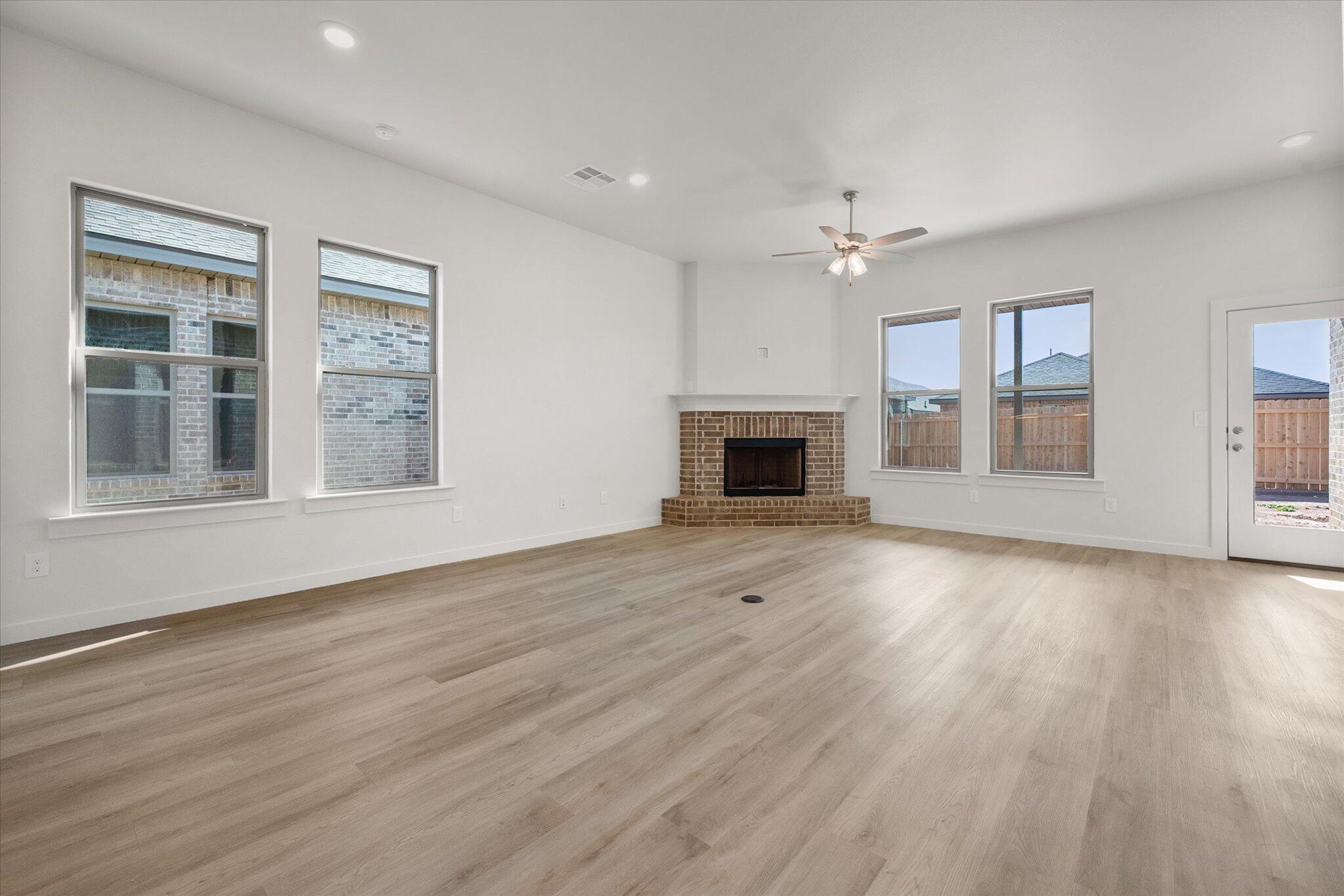 3003 138th Place Lubbock, TX 79423 - Photo 7 of 21 a view of an empty room with wooden floor fireplace and a window