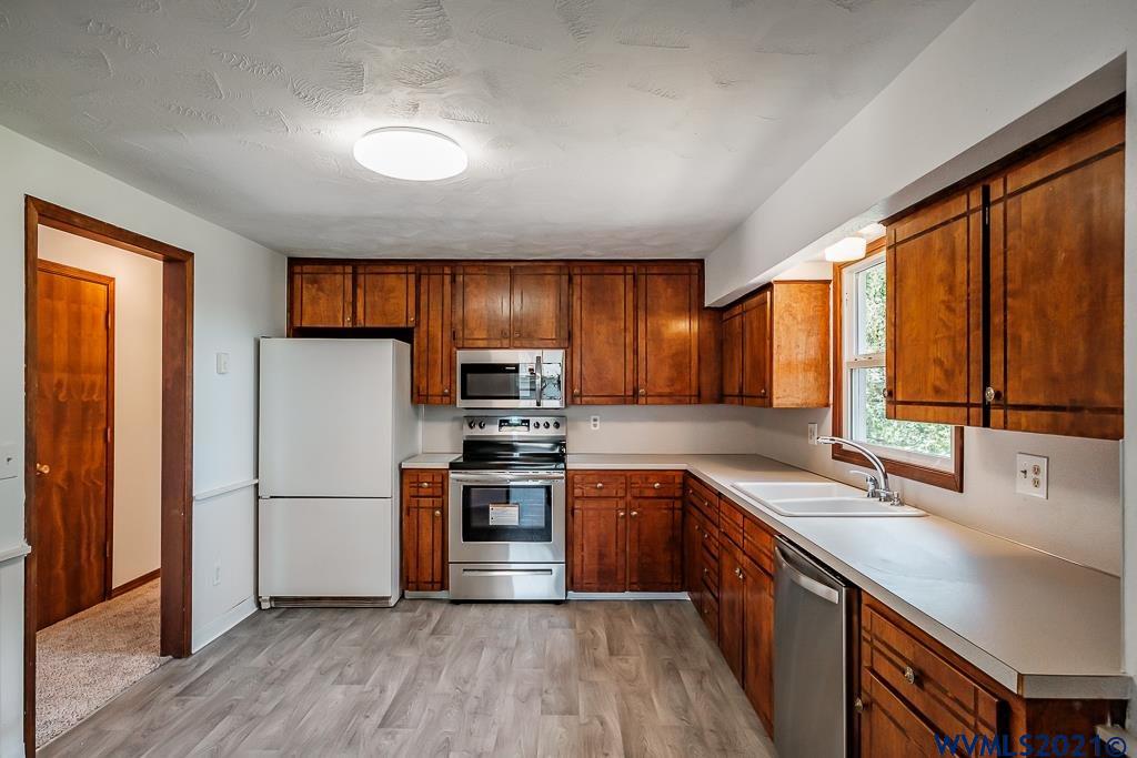 1278 Southwest Maple Street Dallas, OR 97338 - Photo 13 of 42 a kitchen with stainless steel appliances a refrigerator sink and microwave