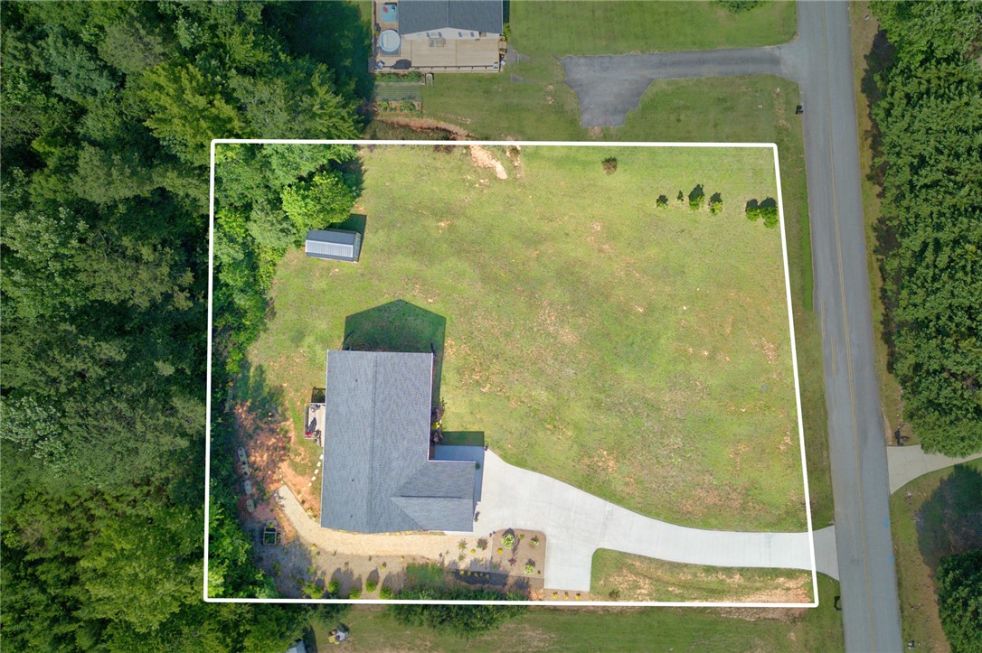 405 Pawnee Drive Walhalla, SC 29691 - Photo 33 of 36 An aerial perspective reveals a vast plot with mature trees bordering a paved drive, enhancing privacy and access.