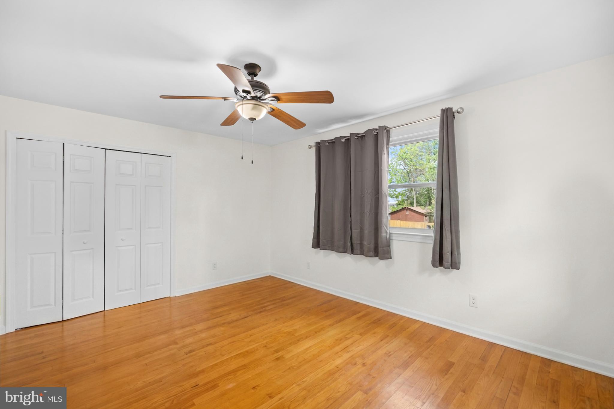 7402 Dunston Street Springfield, VA 22151 - Photo 20 of 37 a view of a big room with wooden floor closet and ceiling fan