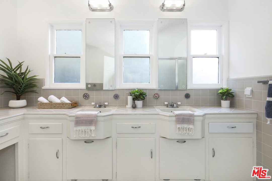 4357 Cedarhurst Circle Los Angeles, CA 90027 - Photo 42 of 51 a bathroom with a sink a potted plant and a window
