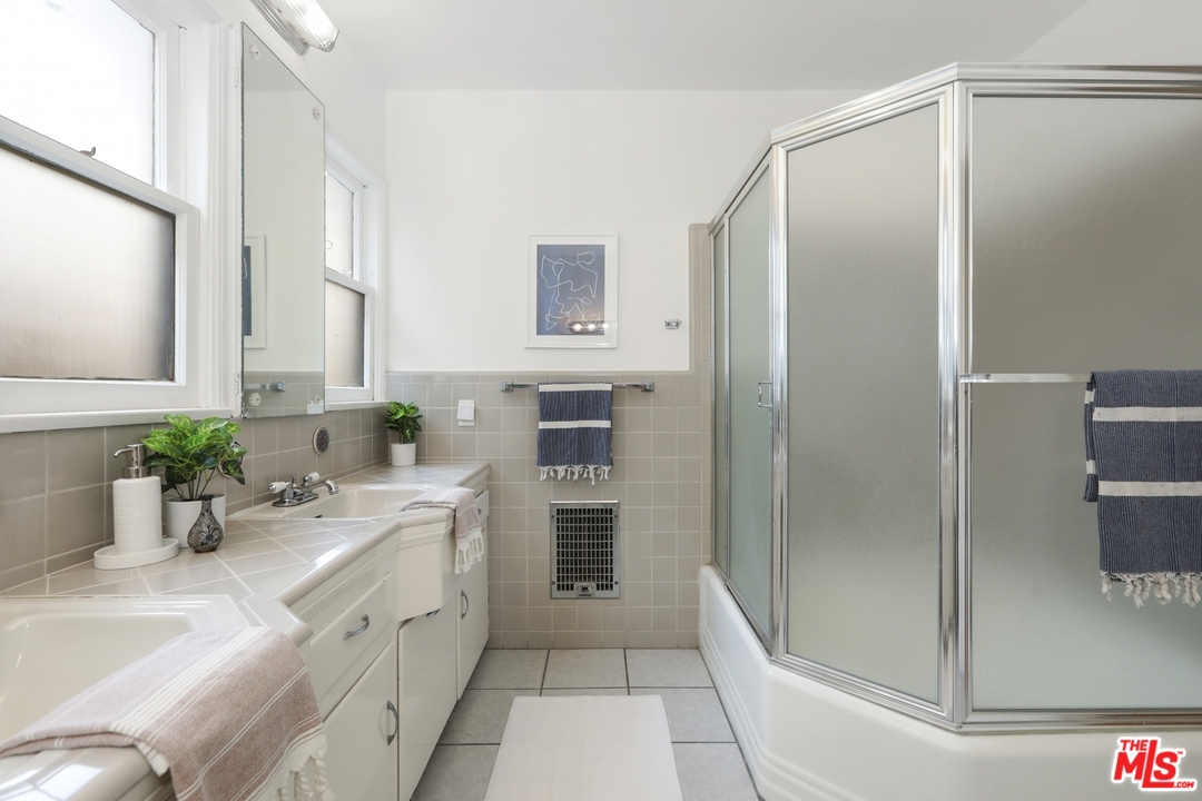 4357 Cedarhurst Circle Los Angeles, CA 90027 - Photo 44 of 51 a bathroom with a double vanity sink a large mirror a shower and vanity