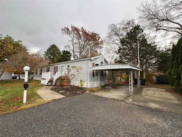 a view of a house with a large tree in front of it