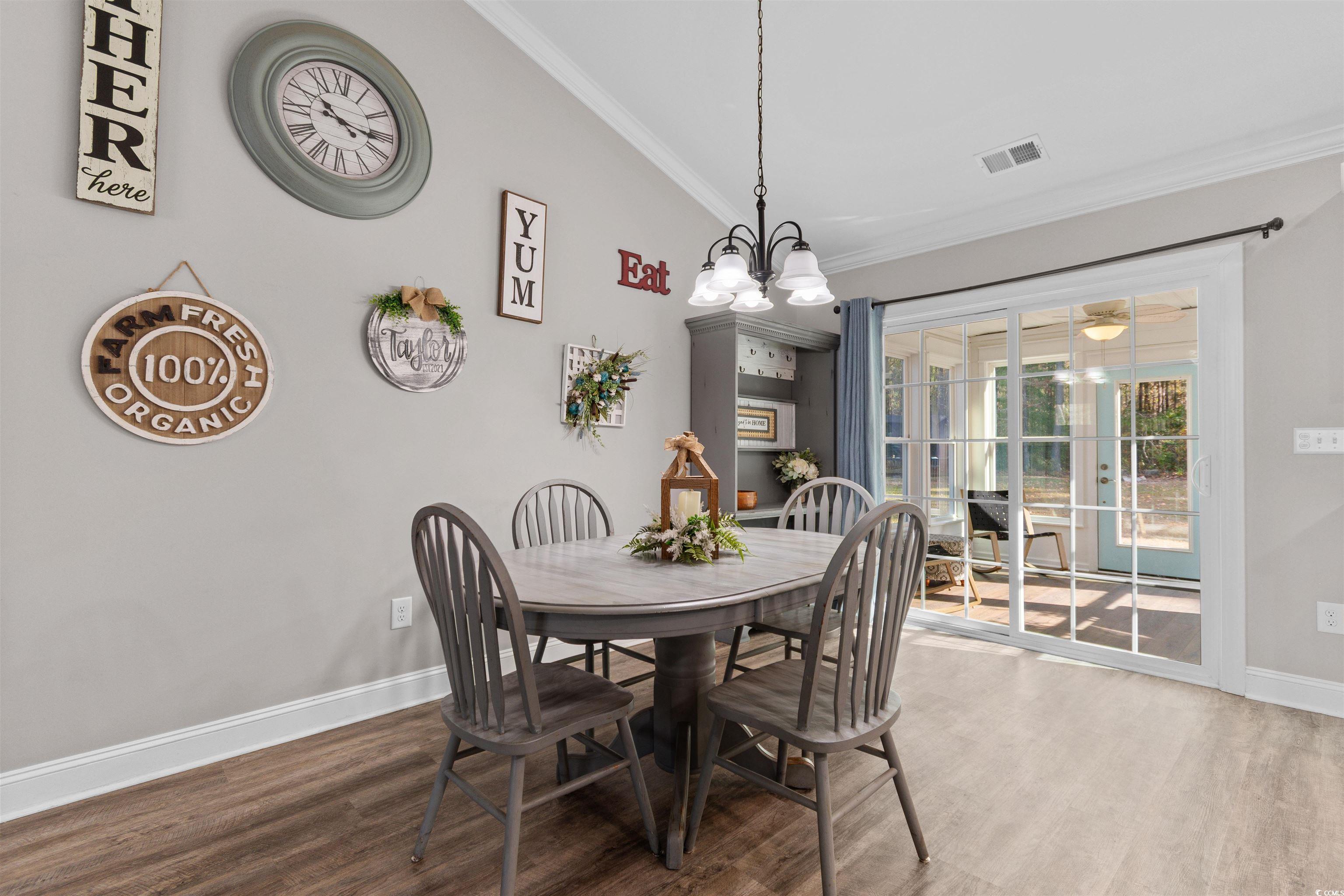 1275 Pinetucky Drive Galivants Ferry, SC 29544 - Photo 11 of 39 Dining area featuring wood finished floors, ornamental molding, and a chandelier
