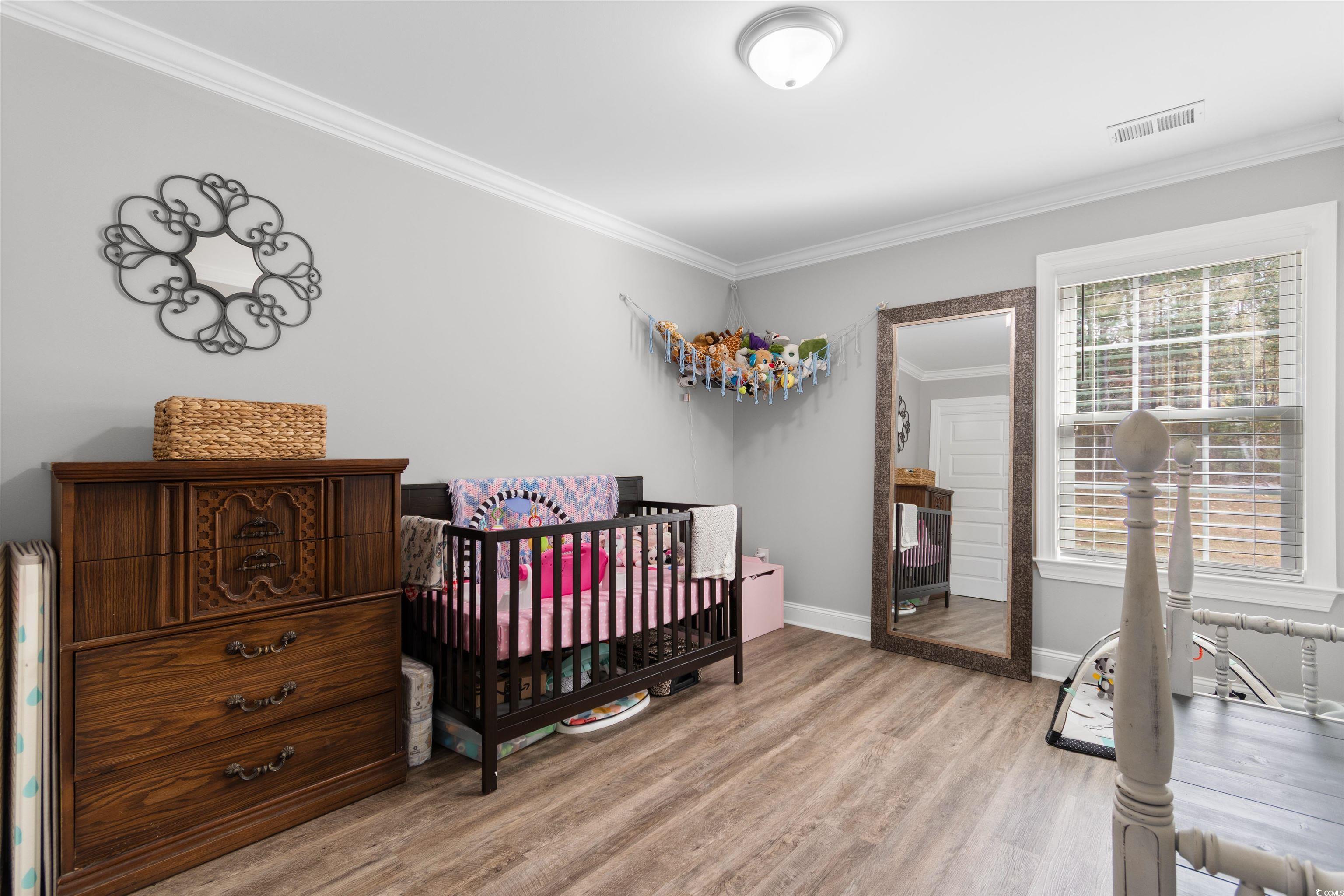 1275 Pinetucky Drive Galivants Ferry, SC 29544 - Photo 24 of 39 Bedroom featuring ornamental molding, light wood finished floors, and a crib