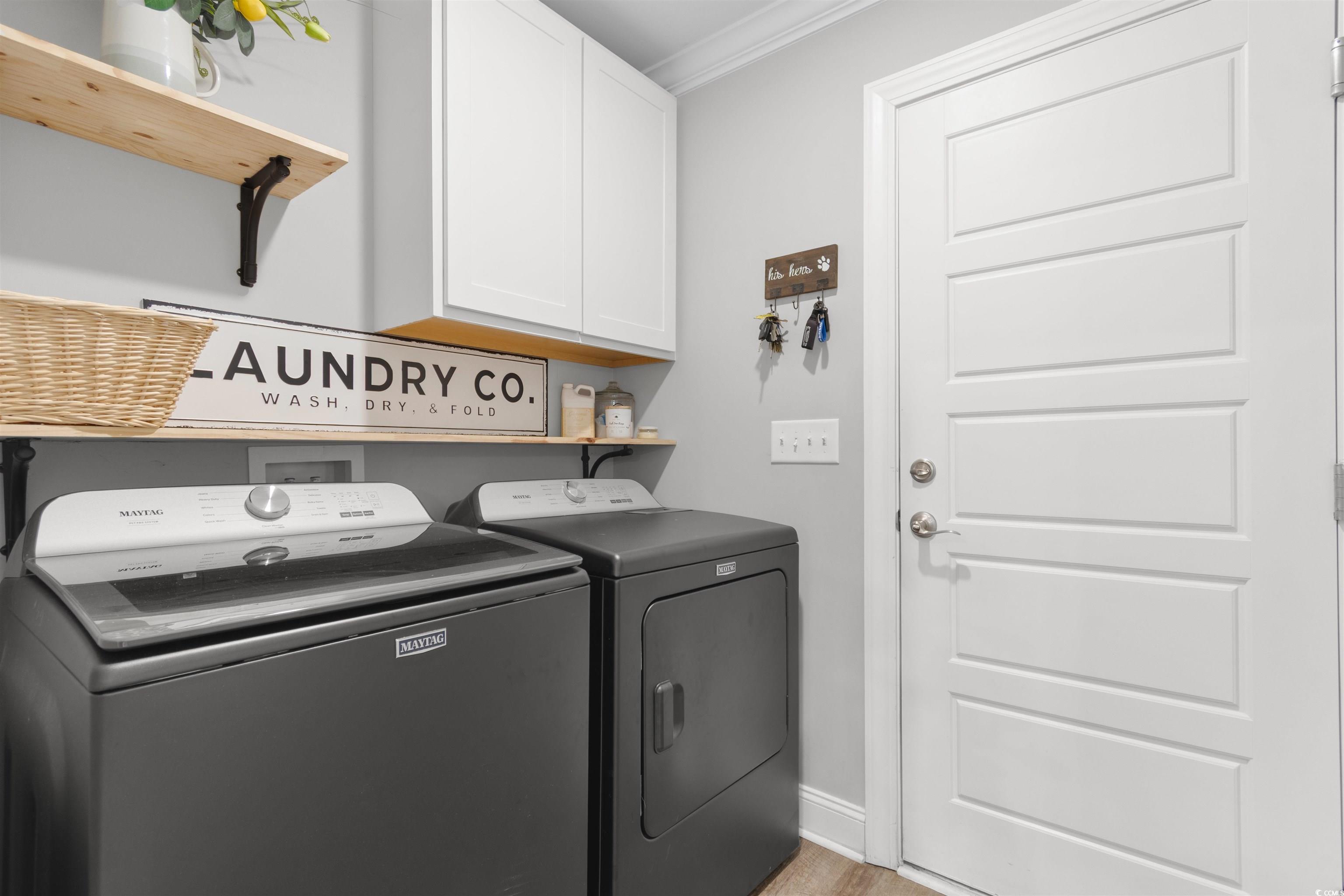 1275 Pinetucky Drive Galivants Ferry, SC 29544 - Photo 26 of 39 Laundry area featuring cabinet space, separate washer and dryer, ornamental molding, and light wood-type flooring