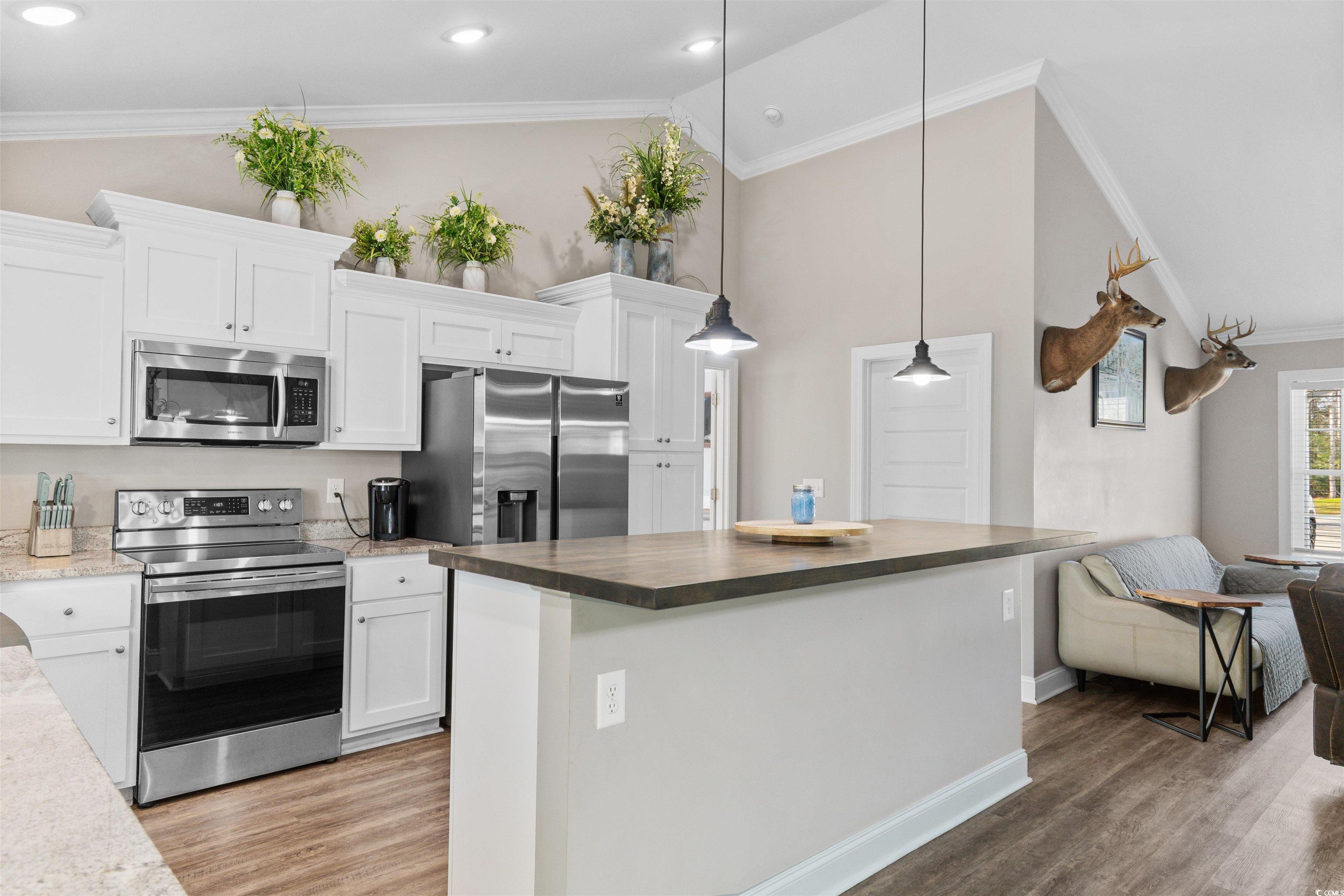 1275 Pinetucky Drive Galivants Ferry, SC 29544 - Photo 5 of 39 Kitchen with crown molding, appliances with stainless steel finishes, white cabinets, a kitchen island, and hanging light fixtures