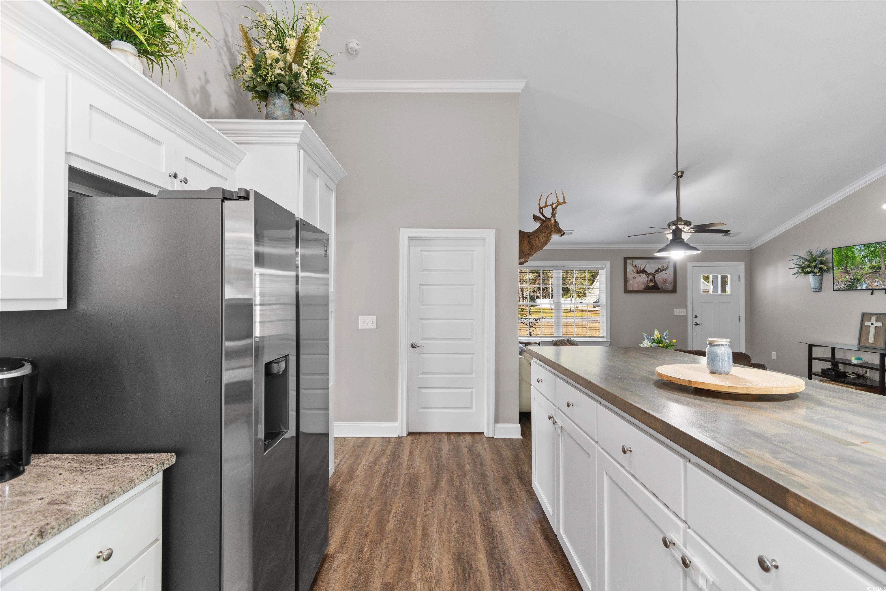 1275 Pinetucky Drive Galivants Ferry, SC 29544 - Photo 7 of 39 Kitchen featuring white cabinetry, crown molding, pendant lighting, stainless steel fridge, and a ceiling fan