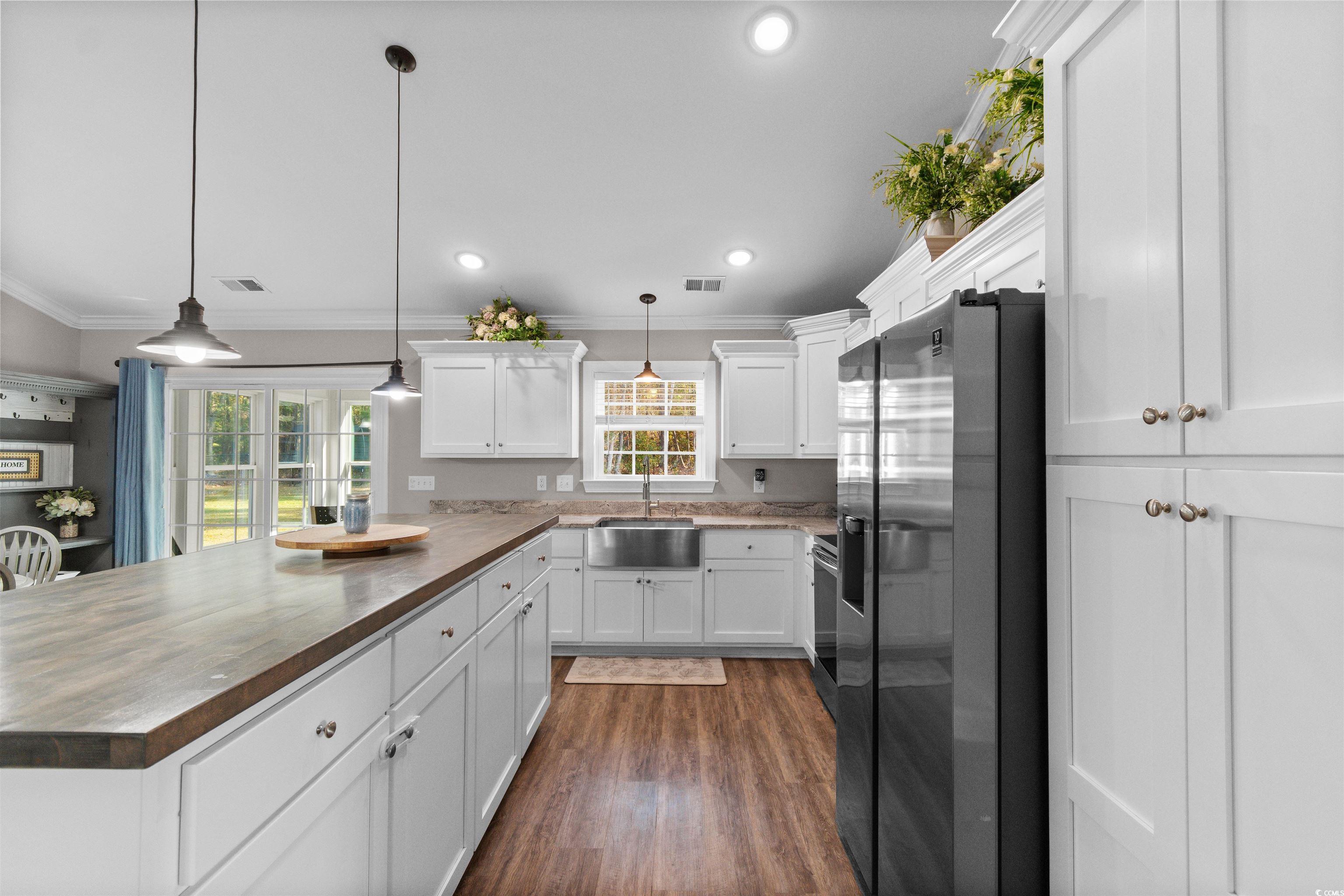 1275 Pinetucky Drive Galivants Ferry, SC 29544 - Photo 9 of 39 Kitchen featuring appliances with stainless steel finishes, crown molding, white cabinetry, decorative light fixtures, and a peninsula