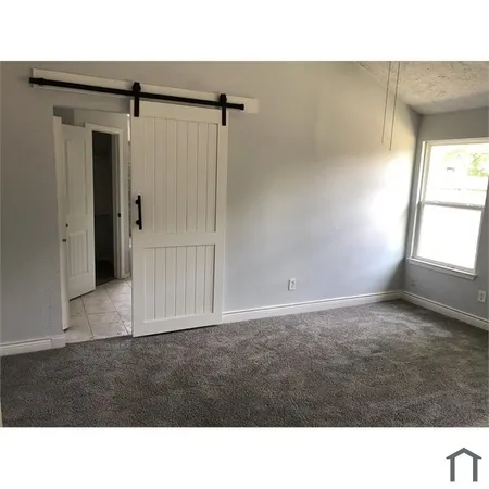 a room with a window and a dresser