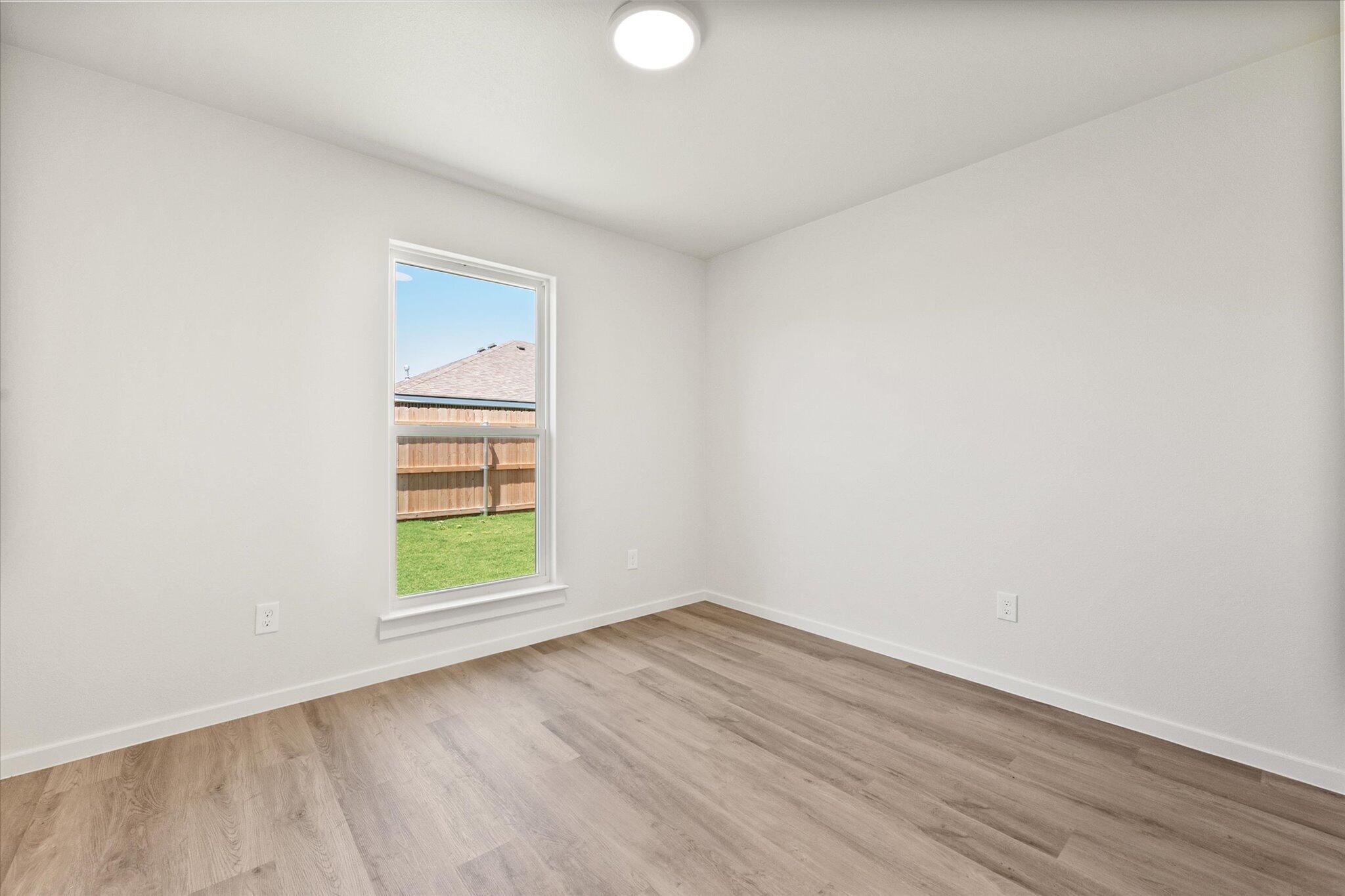 8312 25th Street Lubbock, TX 79407 - Photo 13 of 17 an empty room with a window and wooden floor