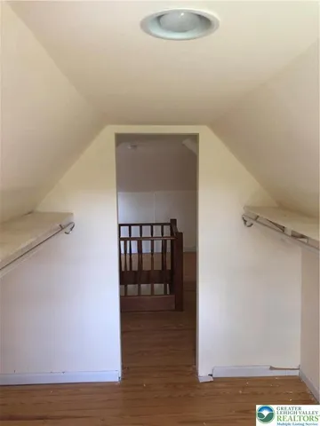a view of a hallway with wooden floor and a cabinet