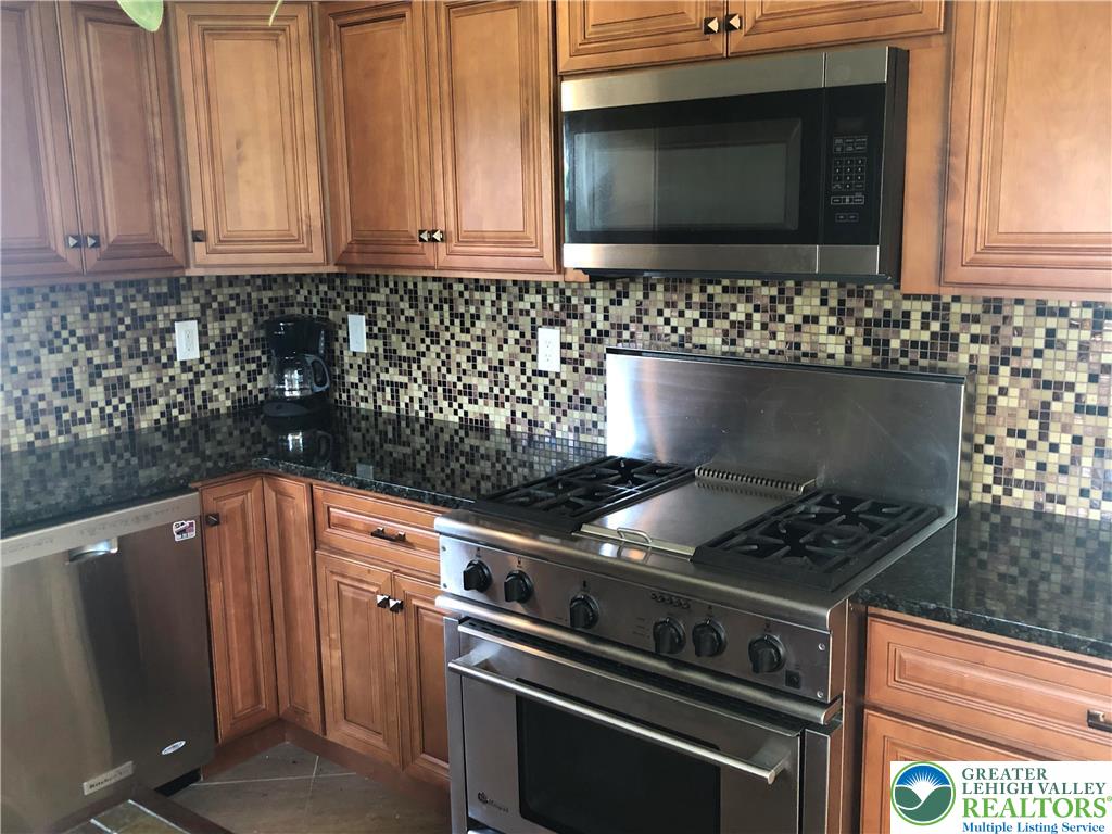1931 Meadows Road Hellertown, PA 18055 - Photo 8 of 20 a kitchen with granite countertop a stove and a microwave