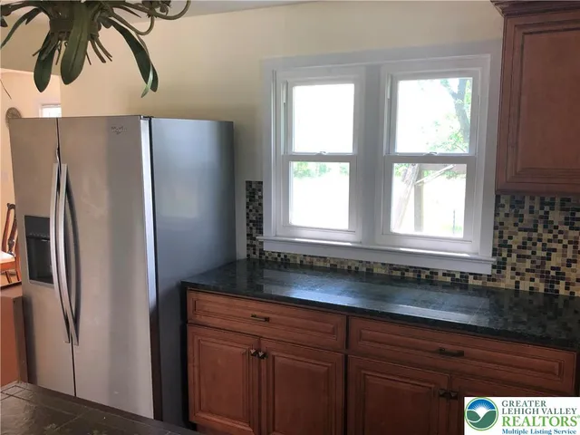 a kitchen with stainless steel appliances granite countertop a refrigerator and a sink