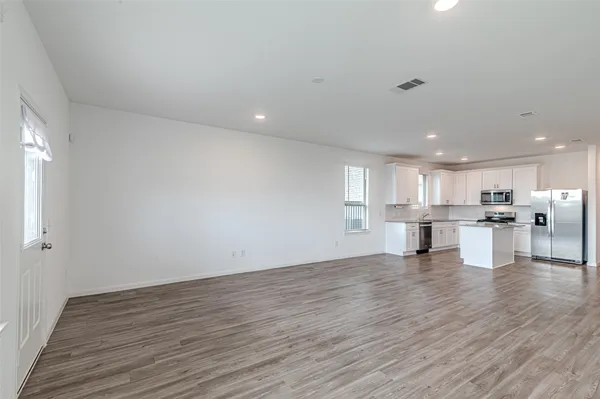 a view of kitchen with kitchen island wooden floor and center island