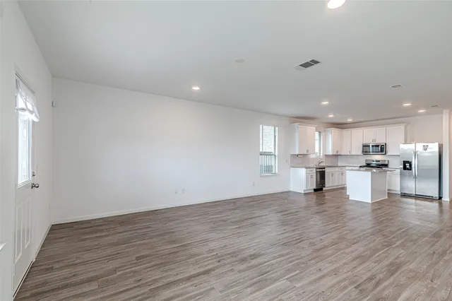 a view of kitchen with kitchen island wooden floor and center island