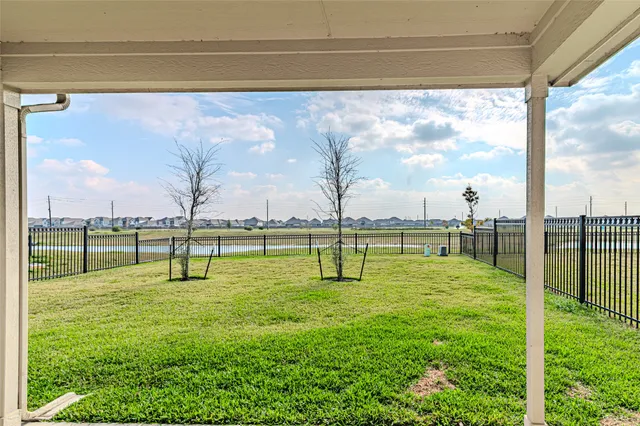 a view of a house with backyard and a tree