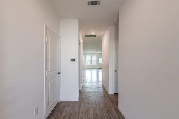 a view of a hallway with wooden floor