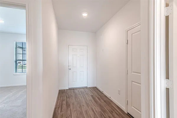 a view of a hallway with wooden floor and entryway