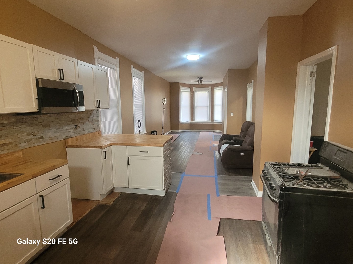 6953 South Loomis Boulevard Chicago, IL 60636 - Photo 8 of 13 a large white kitchen with stainless steel appliances granite countertop a stove top oven a sink dishwasher and white cabinets with wooden floor