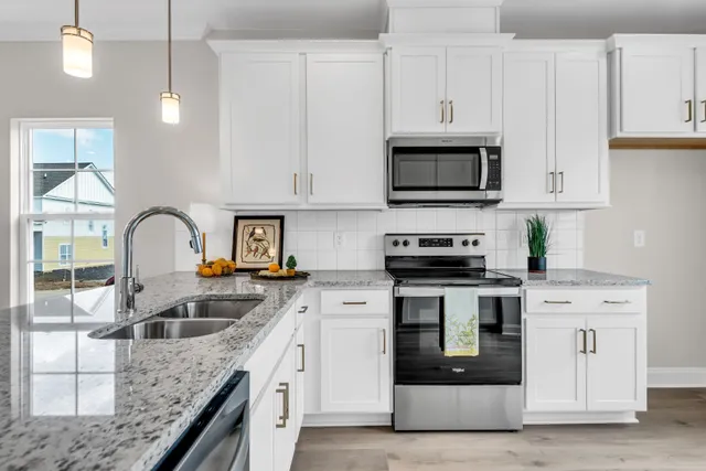 a kitchen with granite countertop a stove and a sink