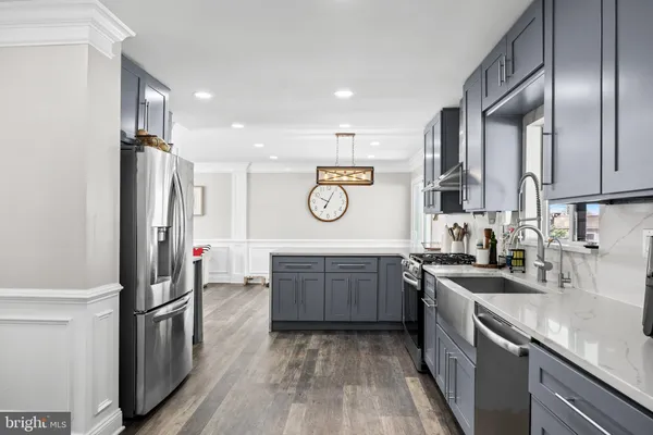 a kitchen with granite countertop stainless steel appliances a sink stove and refrigerator