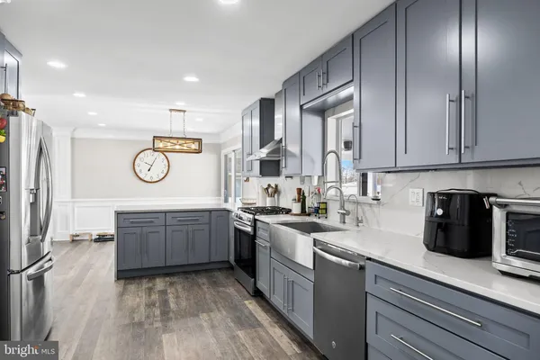 a kitchen with stainless steel appliances granite countertop a stove a sink and a refrigerator