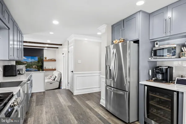 a kitchen with stainless steel appliances a refrigerator sink and white cabinets