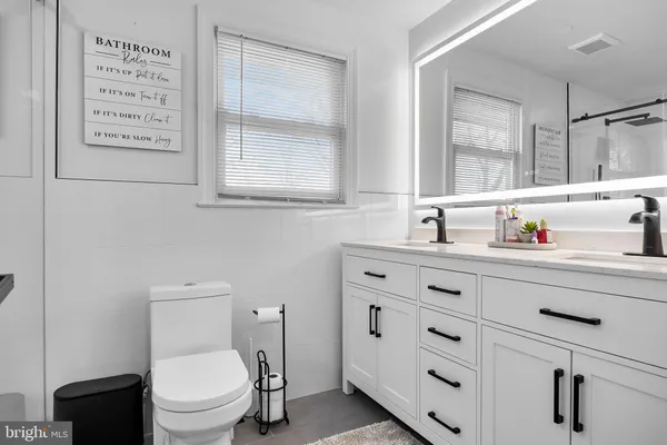 a bathroom with a sink a toilet and a window