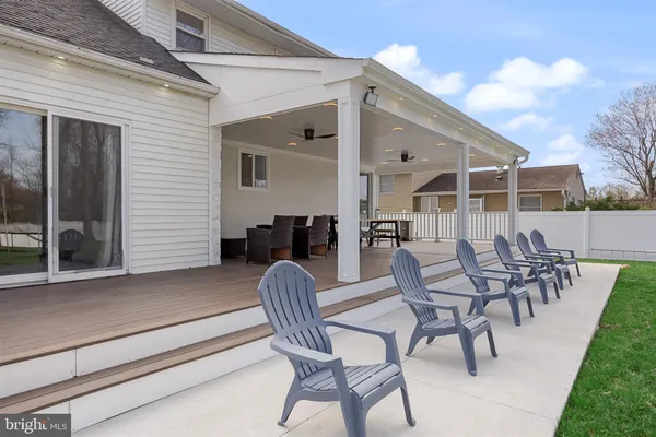 a view of a patio with table and chairs with wooden floor and fence
