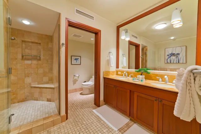a spacious bathroom with a double vanity sink toilet and shower