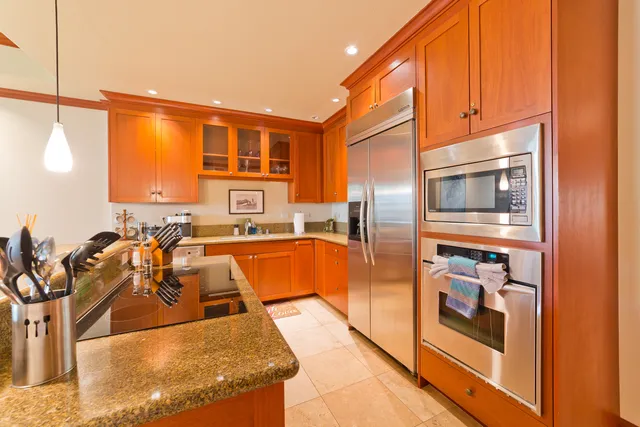 a kitchen with stainless steel appliances granite countertop a refrigerator and a stove