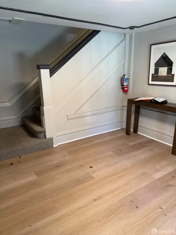 a view of a room with wooden floor and white walls