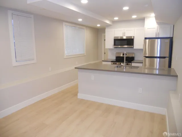 a kitchen with kitchen island white cabinets and stainless steel appliances