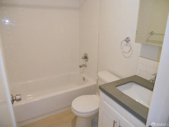 a bathroom with a granite countertop toilet a sink and bathtub