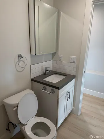 a bathroom with a granite countertop toilet sink and mirror