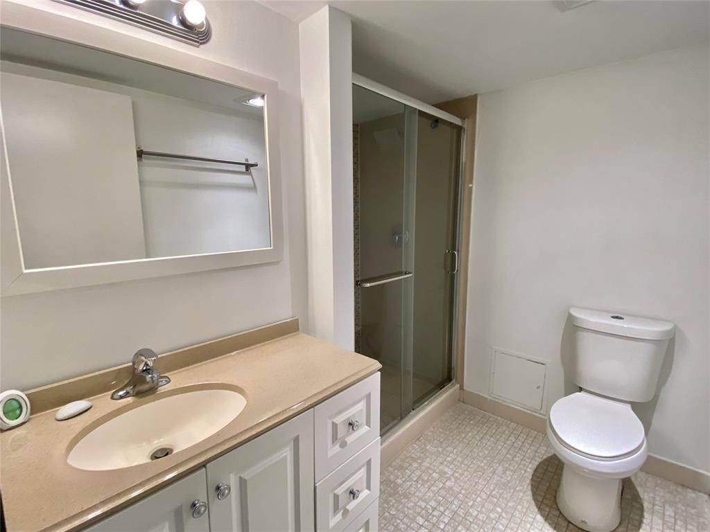 3122 Southwest 20th Terrace, Unit 25B1 Delray Beach, FL 33445 - Photo 14 of 21 a bathroom with a granite countertop toilet sink and mirror