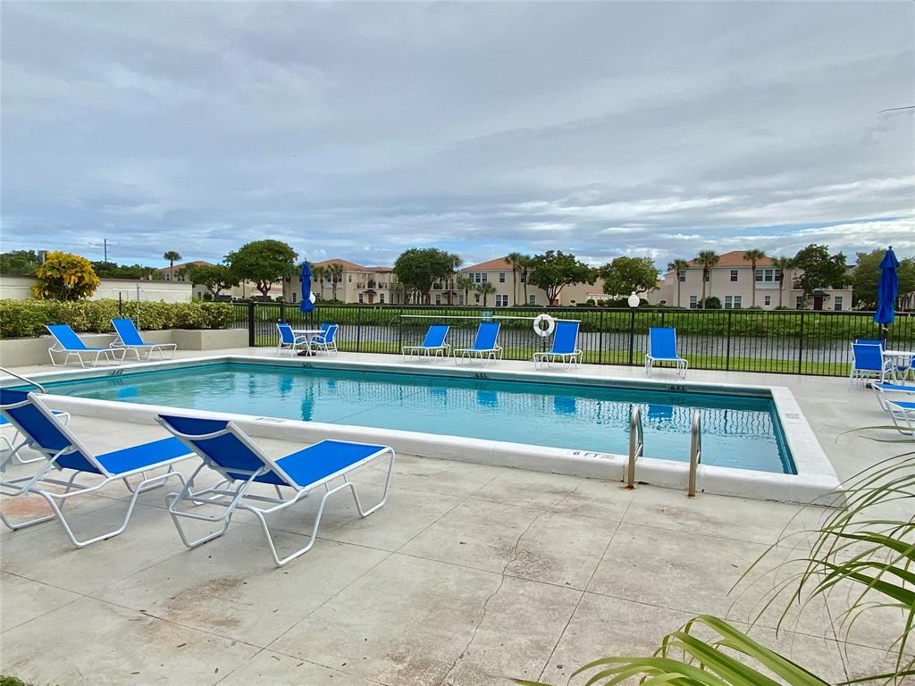 3122 Southwest 20th Terrace, Unit 25B1 Delray Beach, FL 33445 - Photo 21 of 21 an outdoor sitting area with swimming pool and outdoor seating