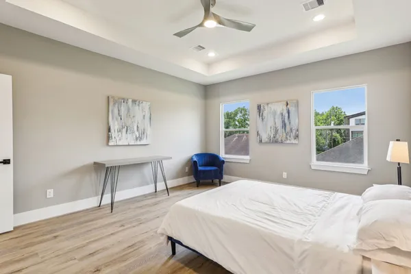 a bedroom with a large bed and a chandelier