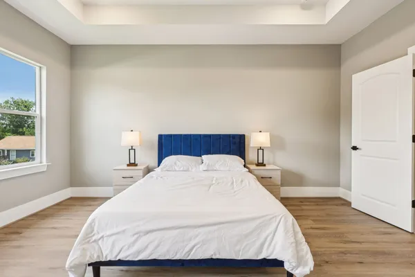 a bedroom with a bed and wooden floor